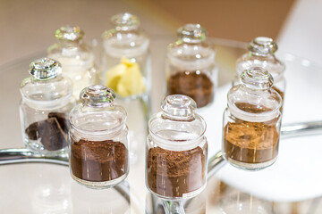 Regular and alkalised cocoa powder on with dar chocolate, in glass jars with lids.