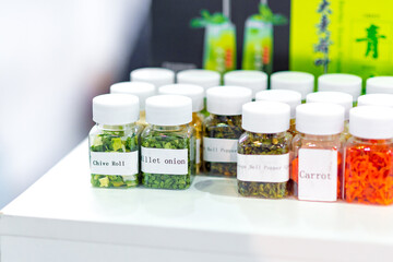 Dried vegetables in glass jars, onions, beets, carrots, pumpkin, bay leaf, banks on wooden background. Superfoods, herbs.