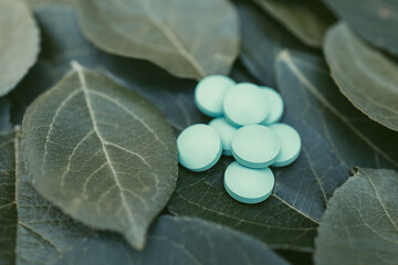 Fototapeta na wymiar a pile of pills on a green leaf, medical drugs from natural