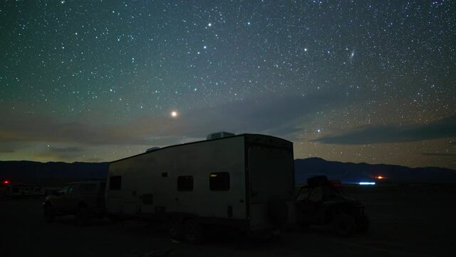 Time lapse of starry sky over recreational trailer at base camp in Death Valley, California