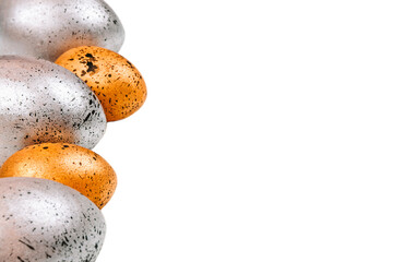 Easter eggs of gold and silver colors with black dots on an isolated background