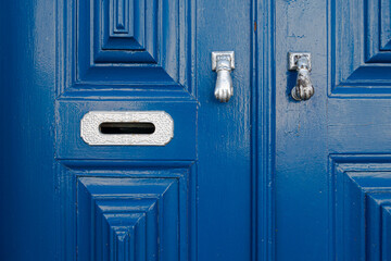 Architectural close-up detail of door with letterbox and door knocker