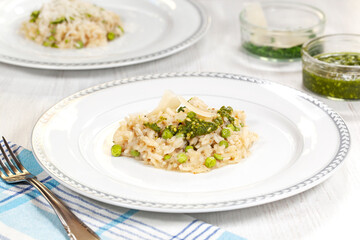 Creamy risotto with green peas, parmesan and pesto. Culinary food.
