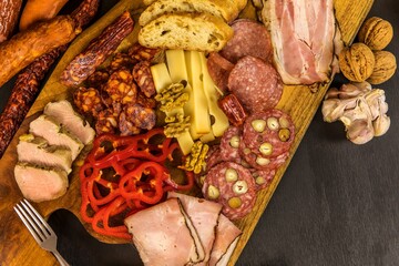 Various kind types of salami, speck and sausages on a wooden table. Fat junk food. Smoked meat. Obesity concept. Overweight.