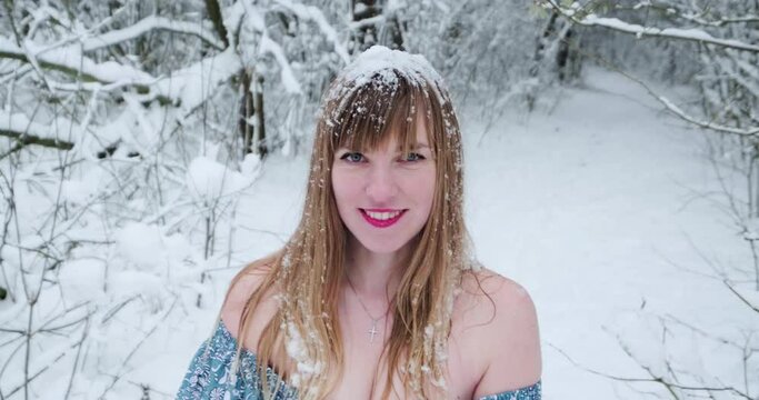 Beautiful smiling confident young white woman pretty face looking at camera posing alone at snowy forest