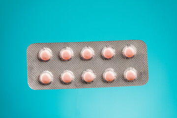 View of tablets in a blister, on a blue background.