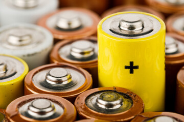 Isolated old battery leakage, hazardous waste concept. Energy abstract background of colorful batteries.
