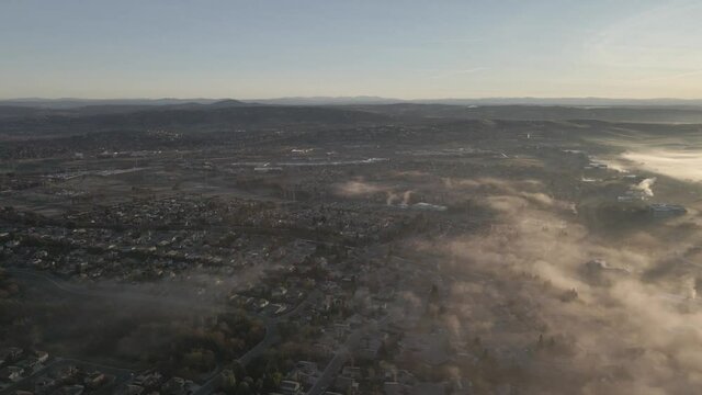 Wide angle drone footage over Folsom, USA on a bright early morning, with misty clouds moving in from the right