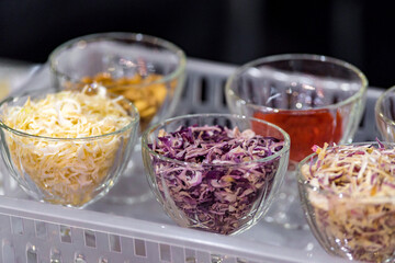 Dried vegetables in glass jars, onions, beets, carrots, pumpkin, bay leaf, banks on straw napkin and wooden background. Superfoods, herbs.