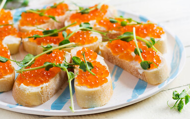 Canape with salmon red caviar. Sandwich for lunch. Delicious food.