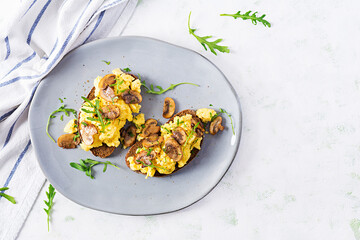 Scrambled eggs and fried mushrooms on bread. Homemade breakfast or brunch meal - scrambled eggs and mushrooms sandwiches. Top view, overhead, copy space