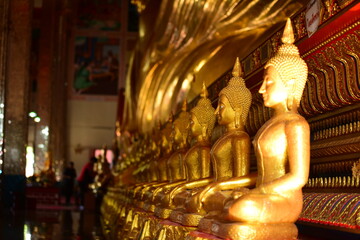 Fototapeta premium The golden Buddha image. Reverence in Buddhist sutras At Wat Luang Pothit, Thailand