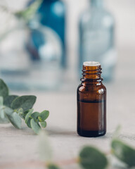 Eucalyptus essential oil and fresh leaves on the stone board.