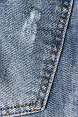 Denim blue jeans texture with scuffs and holes. Abstract background.