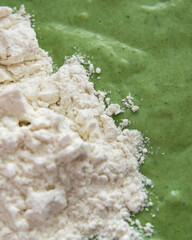 Obraz na płótnie Canvas Green pancake batter with wheat flour. Making spinach or green tea matha pancakes close up.