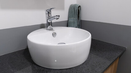 lavamanos blanco lateral con toalla verde colgada