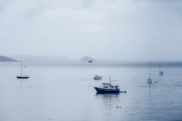 Fototapeta na wymiar Boats moored in the bay outside Cawsands in Cornwall.