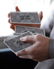 man shuffles a deck of tarot cards