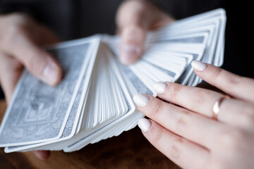 Man holds a deck of tarot cards in his hands and woman draws a card