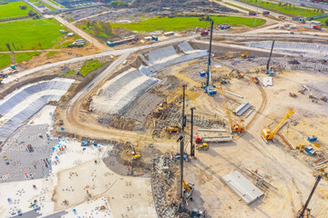 Equipment for installing piles in ground, heavy machines for driving pillars work in laying the foundation building. Construction aerial view height.