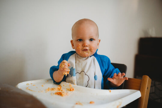 Baby Boy Eating With His Hands Making A Mess With Food All Over Face