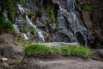large stone with grass on the background of a waterfall. Close-up, mocap