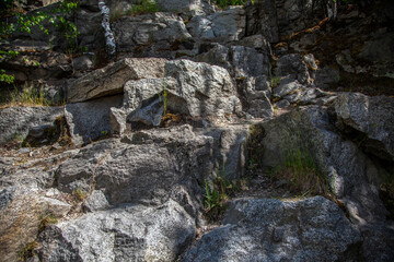 stone boulders protruding from the ground overgrown with grass