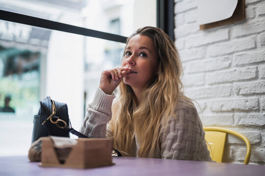 Thoughtful Woman Sitting In Cafe With A Bag On The Table And Thinking About A Plan For The Future