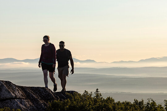 A multi racial couple reaches summit of mountain Appalachian Trail