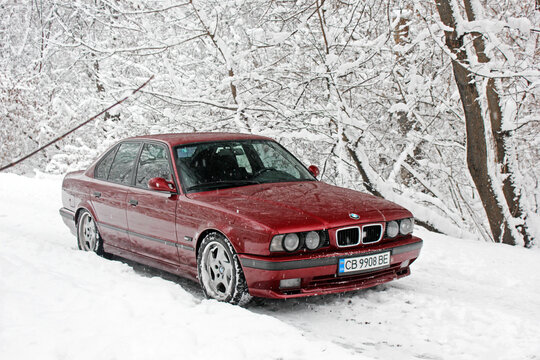 Chernigov, Ukraine - December 21, 2017: Red BMW car on the background of the winter park. Snowy winter and red car. Wonderful winter.