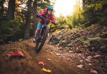 Female mountain-biking downhill during foliage season