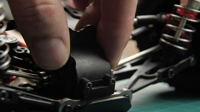 Close-up radio control model buggy car. The hands of the master disassemble the differential