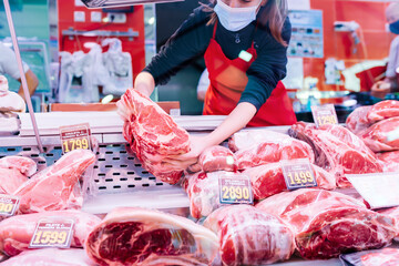 butcher woman placing meat on the counter