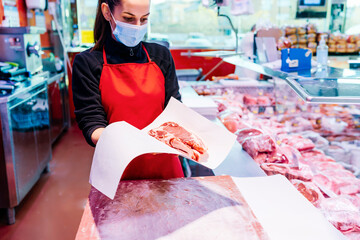 butcher woman packing beef steaks
