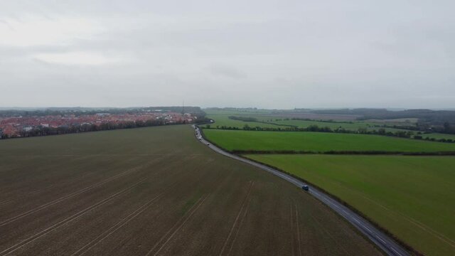 The Adisham road towards Aylesham in Kent. A quiet country road with moving cars.