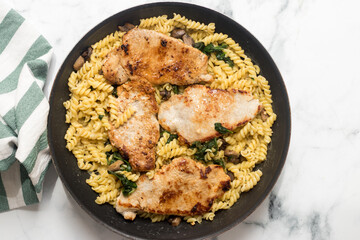 Freshly cooked meat with spinach pasta in baking pan, top view
