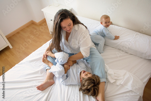 Mom And Children Playing. A Mother And Her Children Play In Bed. Famil