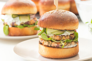 Homemade fish burgers with greens served for two on white plate