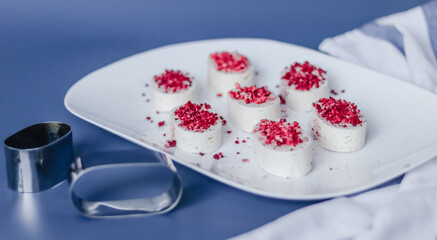 Still life with bird milk souffle on a white plate on a blue background