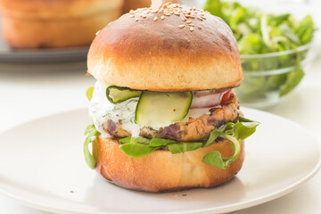 Homemade fish burgers with greens served on white plate