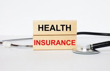 Wooden blocks with text Health Insurance with stethoscope