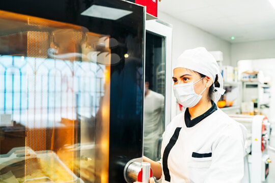 baker controlling the cakes in the oven