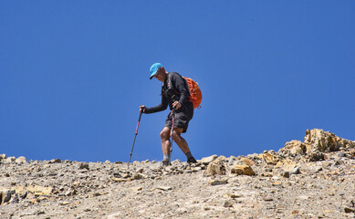 Trekker descending from Santa Rosa Pass towards Sarapo Glacier on the Cordillera Huayhuash circuit,...