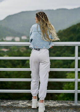 back side of a young woman with blonde braided hair wearing a de