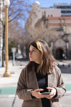 A girl with a smartphone in her hands on a street in Buenos Aires