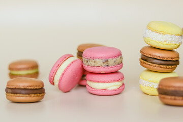 Many multi colored macaroon cakes in stacks on a light background