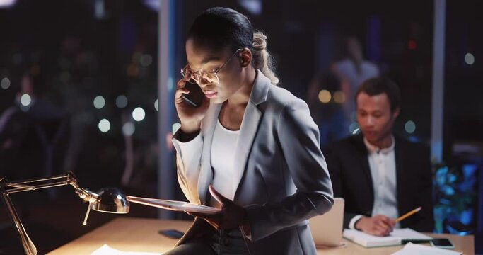 Black attractive young successful female seller executive collaborating with business partner talking in mobile phone on corporate meeting boardroom. Night scene.