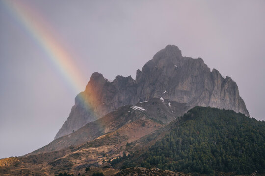 Rainbow against mountain summit during rainy day, Pyrenees, Huesca