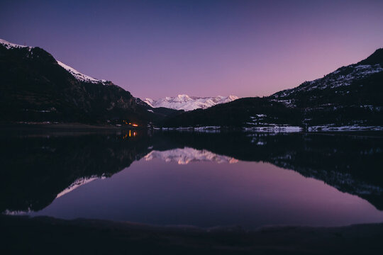Scenic snowcapped mountain reflected on a lake during dusk in Pyrenees