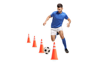 Full length portrait of a soccer player training with obstacle cones